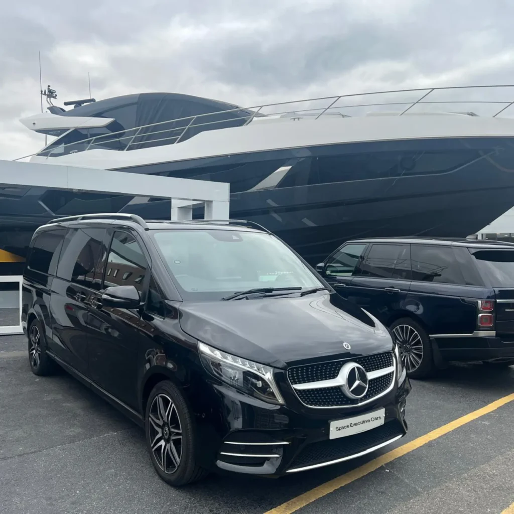 Chauffeur standing next to executive car